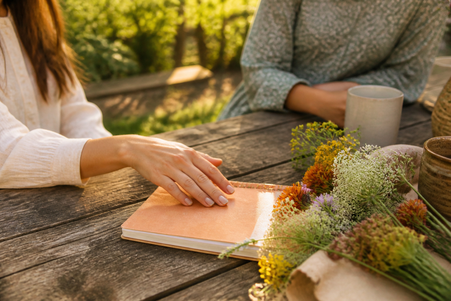 Couple and friend talking in a sunlit living room with a notebook.