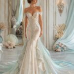 Woman in a beaded mermaid wedding dress with a shimmering blue and white train.