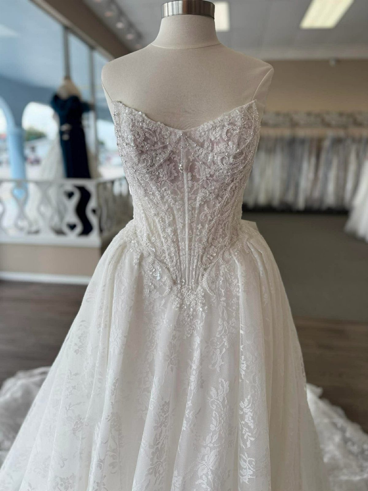 White lace wedding dress with a sequined corset bodice on a mannequin